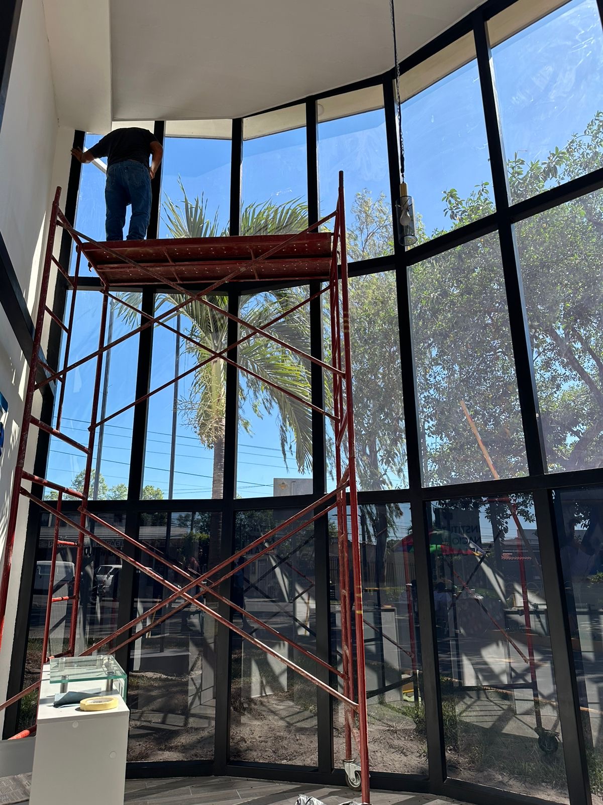 Técnico de SmartFilm instalando película en fachada curva de edificio comercial