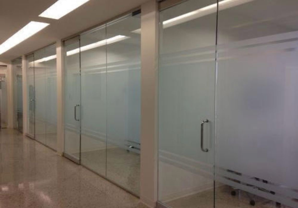 Pasillo de oficina con divisiones frosted SmartFilm, instalación comercial estándar