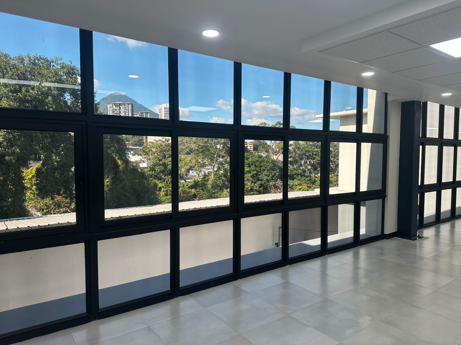 Oficina corporativa con vista panorámica de San Salvador, control solar instalado